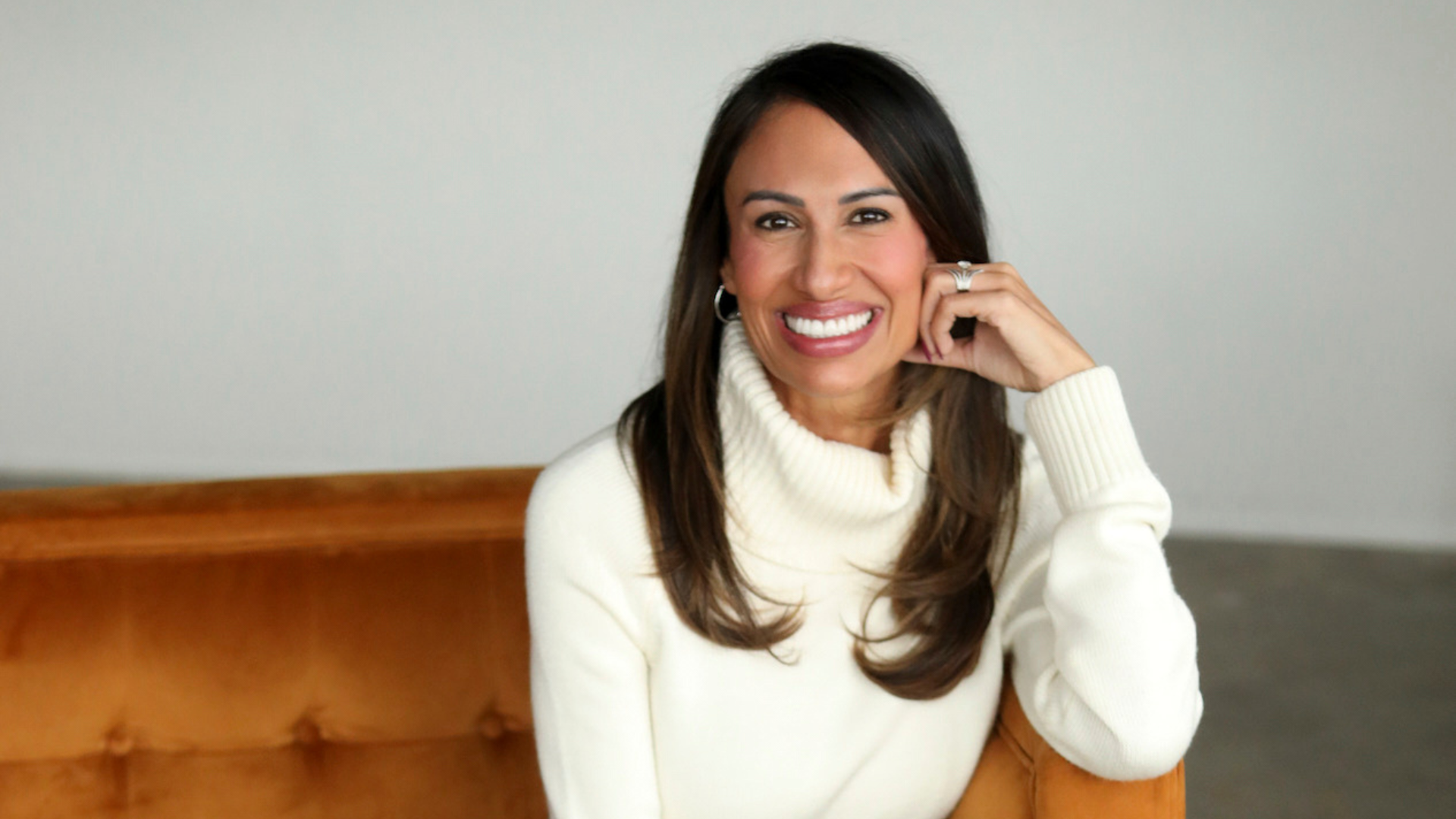 female founder smiling in a bright space, representing sustainable health and a balanced lifestyle for high-achieving women