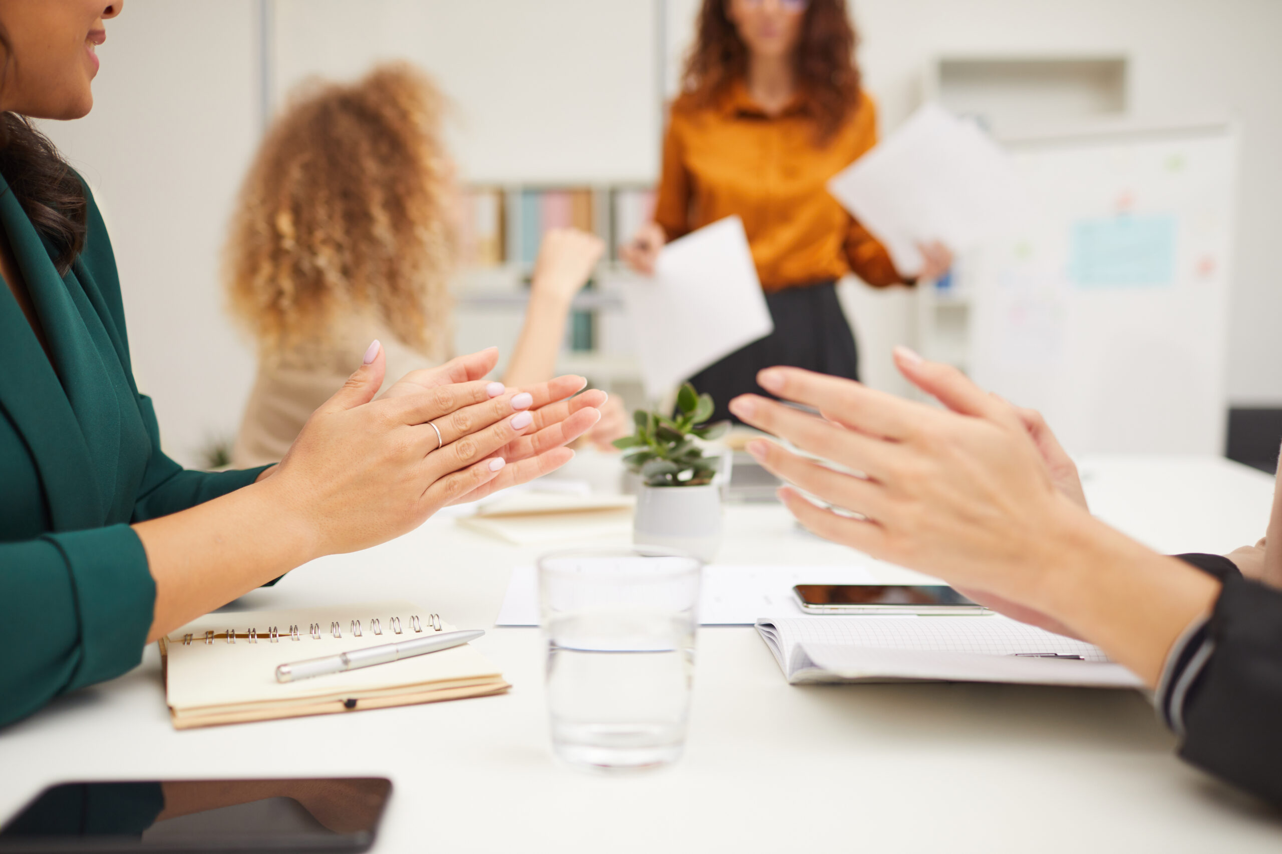 Team members clapping during a business meeting to show support and alignment with leadership